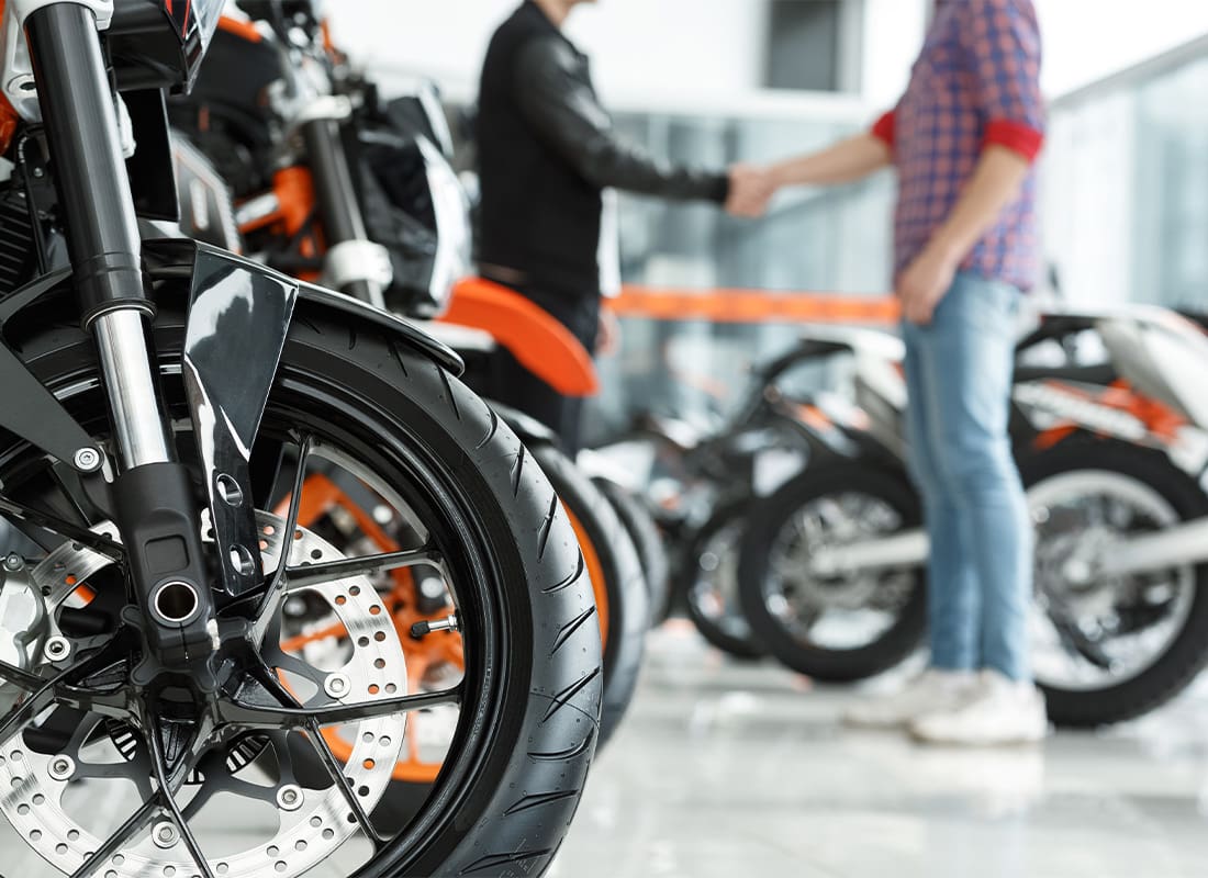 Insurance by Industry - Male Customer Shaking Hands With Motorbike Salon Manager in the Background